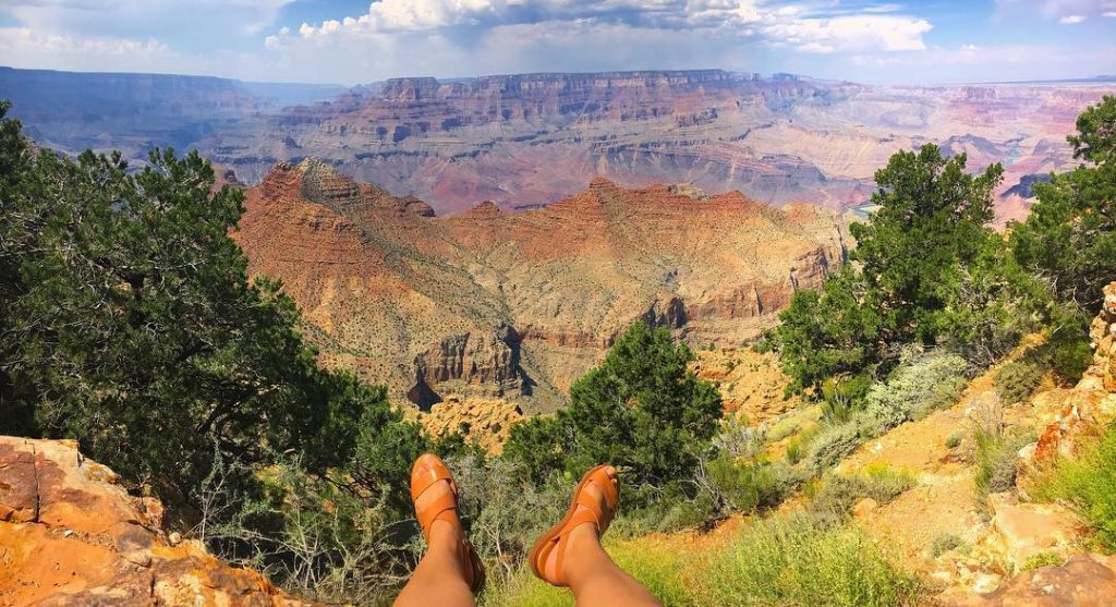 Sitting on the edge of a cliff admiring one of The Seven Natural Wonders…