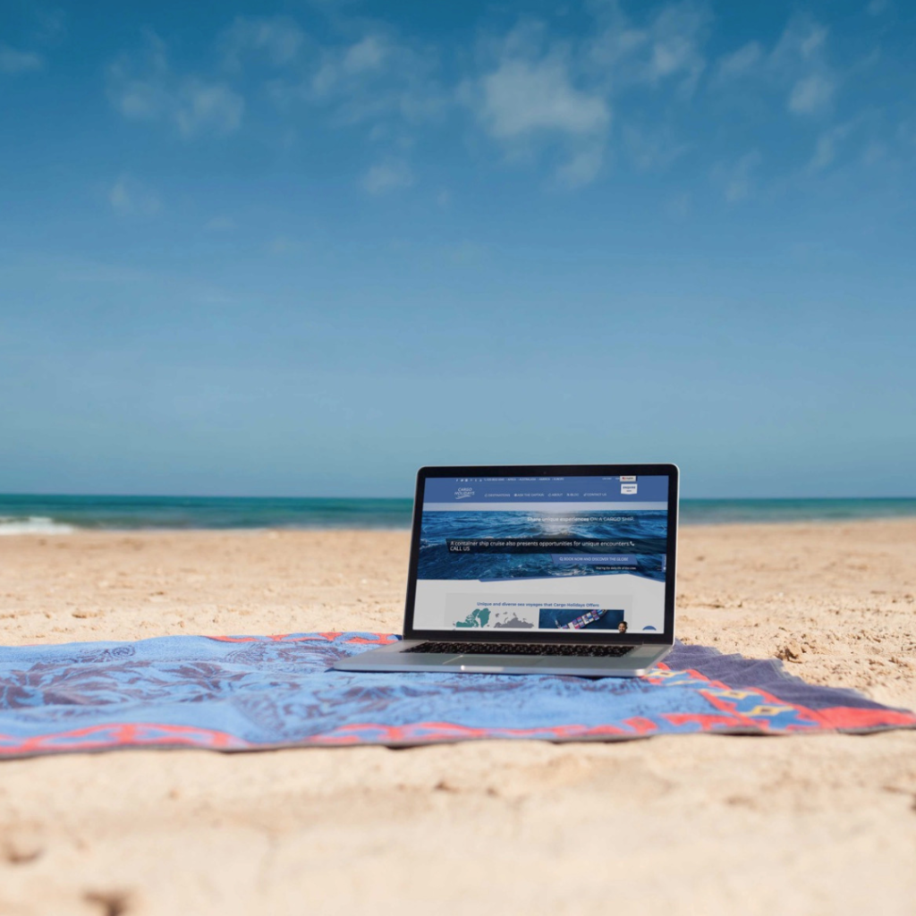 A peaceful beach setting with a laptop, illustrating the essence of slow travel and oceanic exploration in today's fast era.