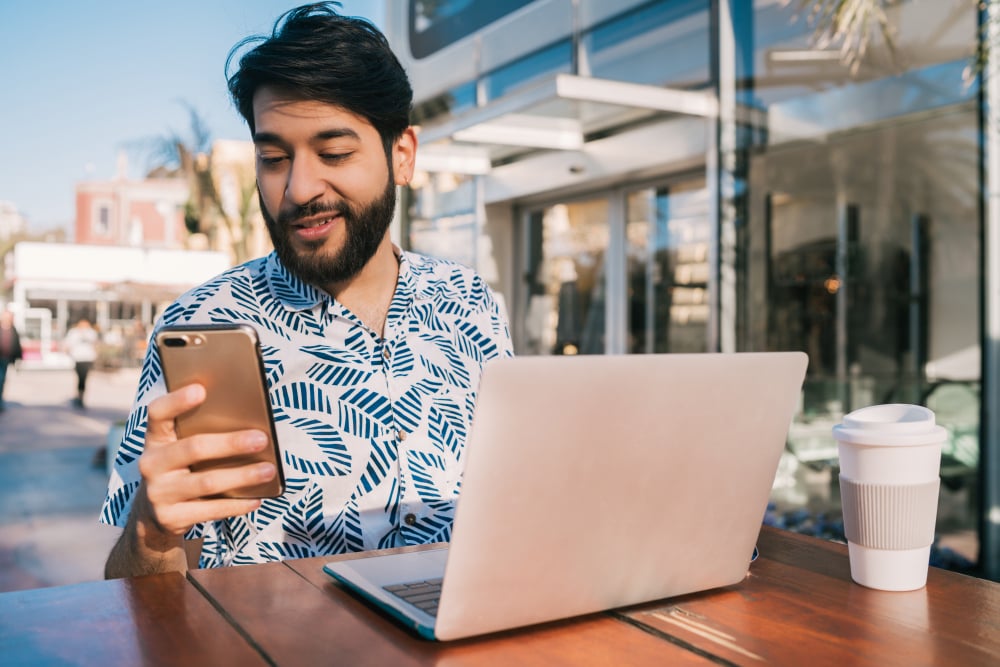 Young man using mobile hotspot on his laptop in a coffee shop
