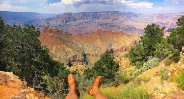 Sitting on the edge of a cliff admiring one of The Seven Natural Wonders…