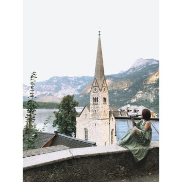 Blue lake hidden between mountains, beautiful decorated houses rising from stoneIt’s somewhat far from…