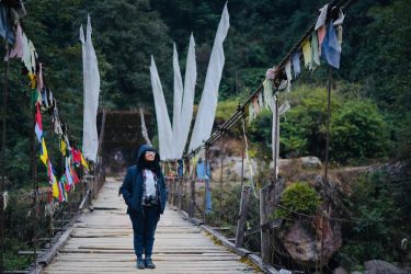 The bridge in Shrikhola is something with its rustic wooden base and colourful prayer…