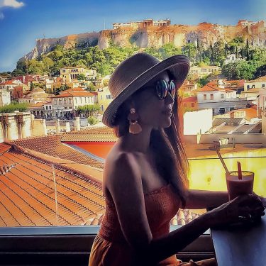 Sipping nice cocktail in the rooftop bar with beautiful panoramic view of Athens city…