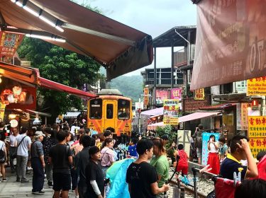 Pingxi street where Sky Lanterns are released. Activities are halted as train is approaching,…